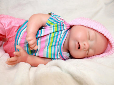 Realistic full silicone reborn baby doll dressed in colorful striped top with pink pants and hat, handmade preemie newborn doll